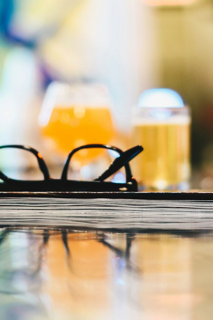 glasses and a book with beer in background to illustrate one of many corvallis oregon date ideas