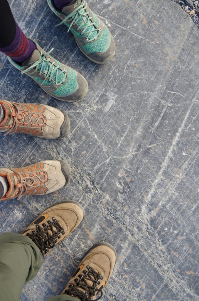 the feet of three people wearing sturdy shoes on a team building activity walking tour - one of many things to do in corvallis oregon