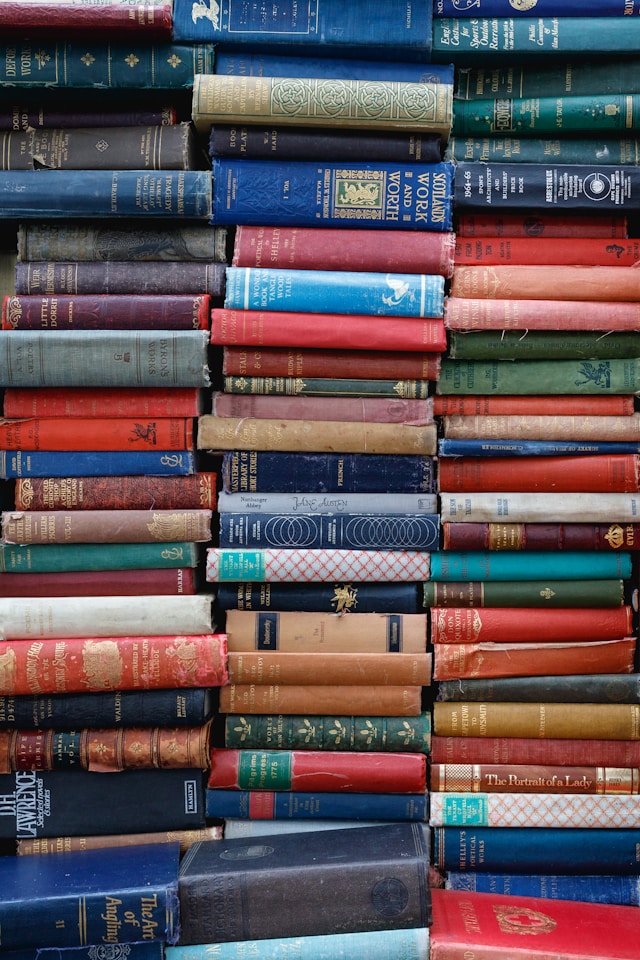 three stacks of weathered books in many colors to show people looking for what to do in corvallis that they could attend a progressive storytelling event on the history of downtown corvallis - like a walking tour